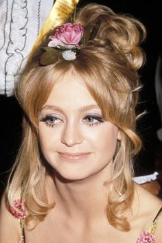 a close up of a person wearing a flower in her hair