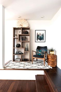 a living room filled with furniture and bookshelves next to a wooden flooring