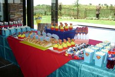 a table filled with lots of food on top of a blue and red table cloth