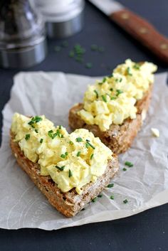 two pieces of bread with eggs on them and chives sprinkled on top