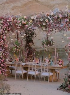 an outdoor dining area decorated with flowers and candles