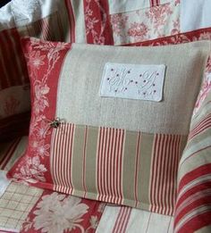 a red and white bed with two pillows on top of it, one has a tag that says love