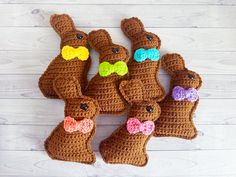 four crocheted stuffed bunnies with bow ties and bows on them, sitting next to each other