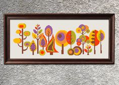 a cross stitch pattern with trees and flowers on the wall in front of a frame