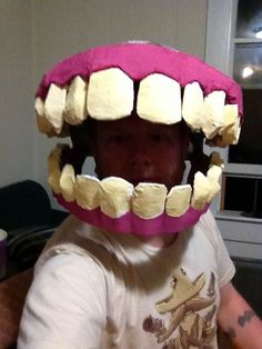 a young child wearing a fake toothy mouth and teeth on it's head