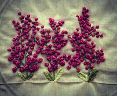 some pink flowers and green leaves on a white cloth