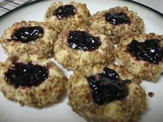 several cookies with blueberry toppings arranged on a white plate, ready to be eaten