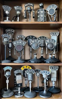 a shelf filled with lots of different types of microphones on top of wooden shelves