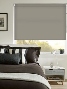 a bedroom with a bed, nightstand and window covered in gray roman blind shades on the windowsill