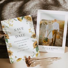 an image of a wedding save the date card and sunflowers on a bed