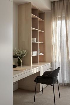 a chair sitting in front of a desk with shelves on the wall next to it