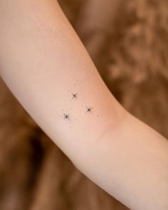 a woman's arm with three stars on it and one star in the middle