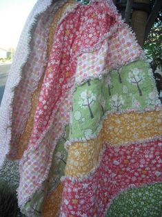 an old quilt is hanging on the back of a car