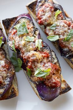 grilled eggplant topped with tomato sauce and herbs