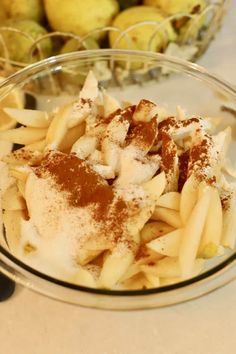 a glass bowl filled with pasta covered in powdered sugar