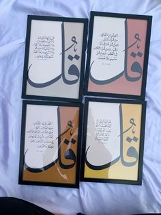 four framed pictures with arabic calligraphy on the bottom, and below them is a white sheet