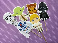 star wars cupcake toppers with stickers on purple polka dot paper, including darth vader, yoda, and luke