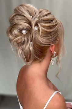 Elegant twisted updo accented with pearls gives a sophisticated and timeless charm for special occasions. The dimensional blonde tones highlight the intricate styling of this chic and classic hairstyle.  // Photo Credit: Instagram @coversbridalcouture Modern High Updo Hairstyles, Classic Low Bun, Gorgeous Wedding Hairstyles, Shiny Black Hair, Cute Wedding Hairstyles, Blonde Updo, Regal Elegance