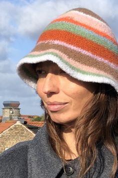 a woman with long hair wearing a multicolored hat