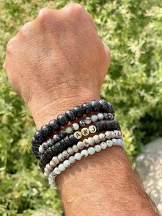 Let's not forget about the guys...They need bling too! Choice of 5 men's beaded stretch bracelets perfect for any guy in your life. Rustic neutrals in black, grey and tan. They are unisex, so get yourself matching bracelets! Can be personalized, just note initials or word in checkout. Perfect gift for dad, boyfriend, brother, bestfriend, surfer, beach bum...My guy's choice? Rustic Black, Rustic Grey & Silk Stone!    Choice of: Rustic Black Mala 7x10mm Charcoal Black Sandcast 6x8mm  Rustic Grey Mala 6mm Black Silk Stone/Onyx Marble 6mm Kiwi Jasper 6mm *  Approximate men's bracelet length: 8 inches (6mm beads) & 8.25 inches (8-10mm beads)  *  Designed to fit slightly loose on an average 7.5 in wrist  *  Custom sizes are welcomed, please indicate wrist size and/or preferred fit in a note in c Bracelets For Guys, Guys Beaded Bracelet, Men’s Bracelet Beads, Men’s Beaded Bracelet Ideas, Men’s Beaded Bracelets Diy, Boy Bracelets, Customizable Mens Beaded Bracelets, Boys Bracelets, Slide Bracelet