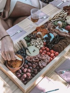 a person reaching for food in a tray on a table