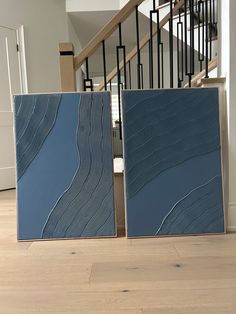 two blue tiles sitting on top of a hard wood floor next to a banister