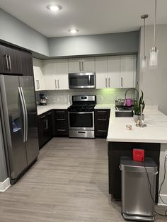 a kitchen with stainless steel appliances and white counter tops