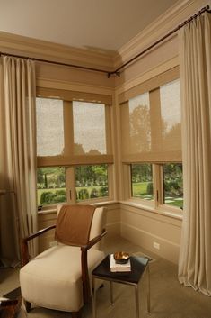 a living room filled with furniture and windows covered in shades on top of the curtains