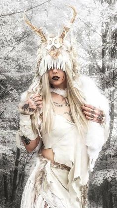 a woman with long hair and horns is dressed in white