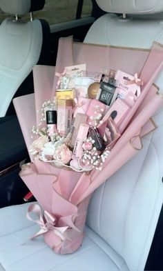 a pink bouquet sitting in the back seat of a car filled with personal care items