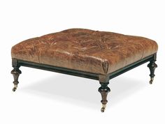 a brown leather ottoman sitting on top of a wooden table