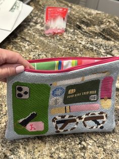 a person is holding a small purse on a counter top with toothbrushes in it