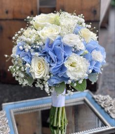 a bouquet of white and blue flowers in front of a mirror