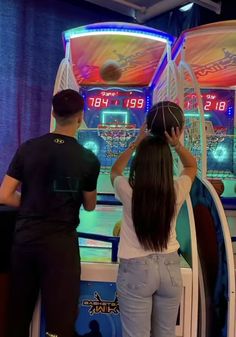 two people standing in front of a video game machine