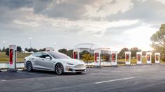 an electric car is parked in front of two charging stations with red and white lights