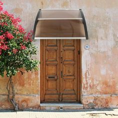 an old building with a wooden door and planter on the sidewalk next to it