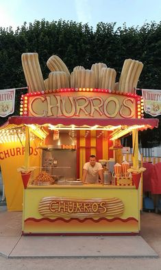 a man standing in front of a food stand with corn on it's roof