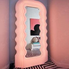 a room with pink walls and a mirror on the wall