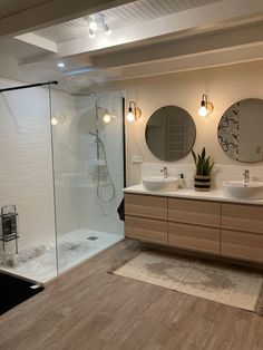 a large bathroom with two sinks and a shower stall in the middle of the room