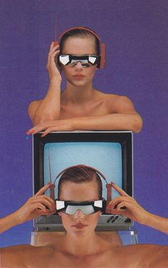 two people with headphones on their ears are looking at a television screen and the man is wearing blindfolds