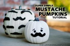 two white pumpkins with black mustache designs on them