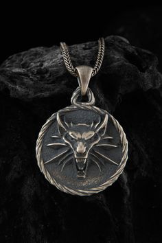 The silver wolf pendant is a stunning piece of jewelry that is perfect for fans Wolf lovers. Crafted from high-quality silver, this pendant features a beautifully detailed wolf head, a symbol that is closely associated with the Witcher universe. The intricate design and attention to detail make this pendant a truly unique and eye-catching accessory that is sure to draw compliments. Whether you wear it as a statement piece or as a subtle nod to your fandom, this pendant is a must-have for any Wit Wolf Medallion, Witcher Medallion, Wolf Pendant Necklace, Black Chain Necklace, Wolf Pendant, Wolves Pendants, Wolf Necklace, Handmade Wooden Boxes, Wolf Jewelry