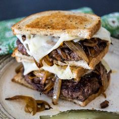 a grilled cheeseburger with onions and melted cheese on a toasted bun