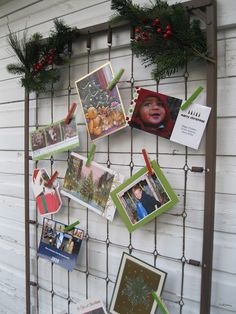 a bunch of pictures hanging on the side of a building with christmas decorations around them