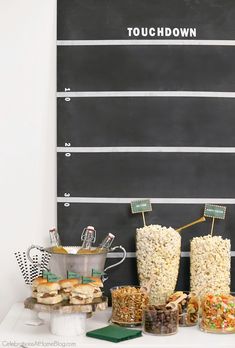 a table topped with lots of food next to a chalkboard sign that says touchdown