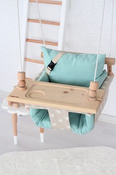 a wooden swing bed with blue and white pillows