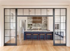 an open kitchen and dining room with glass doors that lead to the living room area