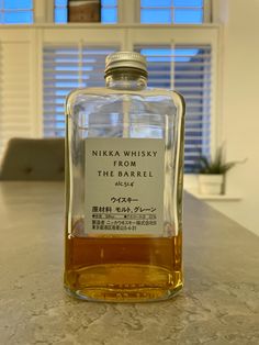 a bottle of nikka whisky sitting on top of a counter next to a window