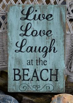 a sign that says live love laugh at the beach