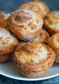 a white plate topped with sugar covered pastries on top of a blue tablecloth